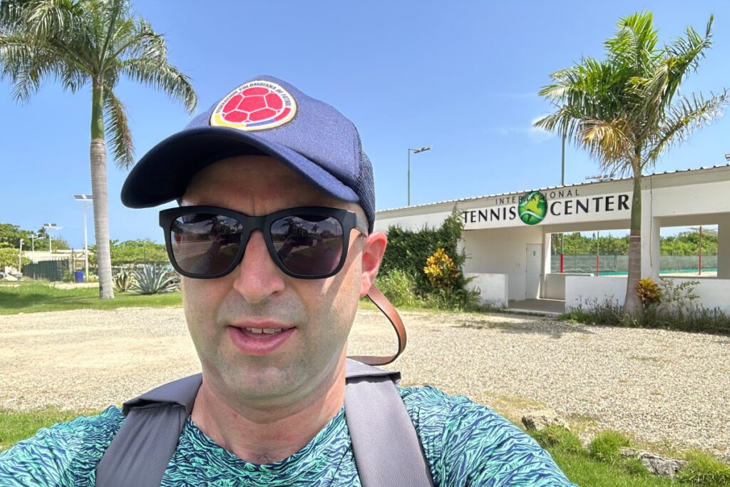 American tourist (Eric Claggett) takes selfie in front of International Tennis Center, Ocean Village in Sosua, Dominican Republic.