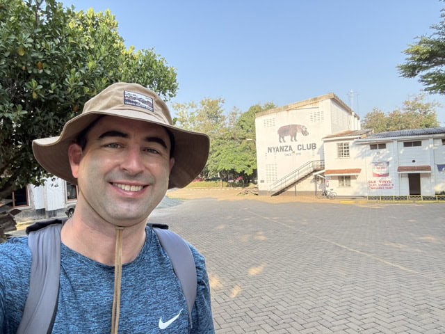 American visitor takes selfie at the famous Nyanza Club tennis sign, which says founded in 1915.