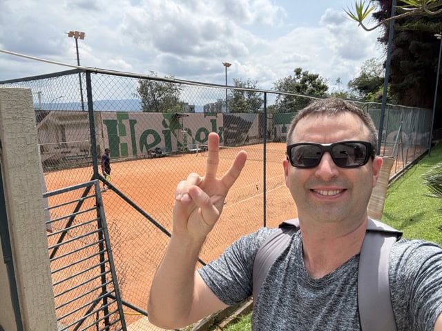 Nyarutarama Sports Centre tennis courts in Kigali, Rwanda -American visitor selfie with peace sign.